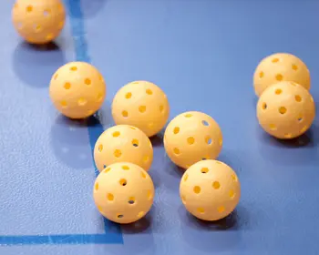 Gula Innebandybollar på blått golv