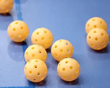 Gula Innebandybollar på blått golv